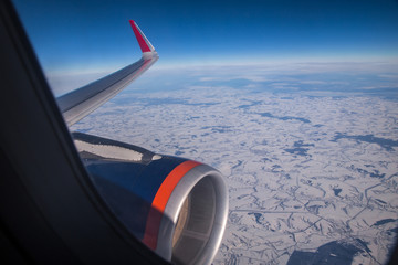 sky through aircraft window onto jet engine