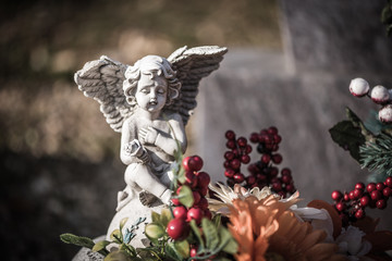 Engelsfigur auf einem Grab mit Blumen
