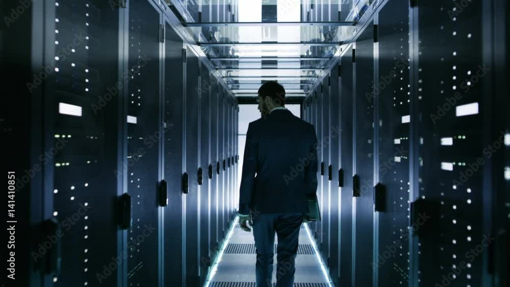 Aufkleber data center technician walking through server rack corridor visually inspecting working server cabin