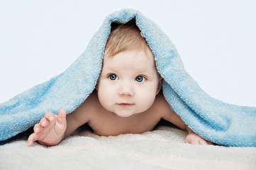 Newborn child relaxing in bed after bath or shower. Nursery for