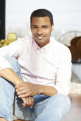 Relaxed young man portrait. Shot of an African American young man relaxing at home on the sofa while looking at camera and smiling.