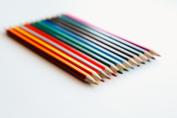 Colored two-color double-sided pencils are stacked, white background