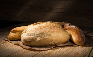 Assortment of baked bread on wooden table background