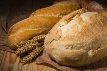 Assortment of baked bread on wooden table background