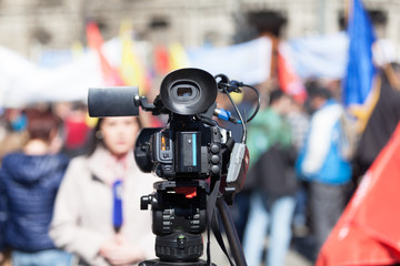 Filming street protest using a video camera. Media covering of a demonstration.