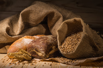 Assortment of baked bread on wooden table background