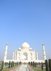 Obraz premium Iconic perspective of the Taj Mahal mausoleum in Agra, India, with the reflection pool and the main building dome framed by the minaret towers.