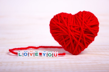 Woolen heart and bands words love you.