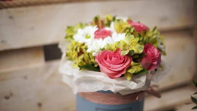 Beautiful summer bouquet of flowers in the hat box on the vintage blue wooden background. Close-up.