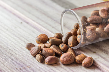 Seeds scattered from a jar on a gray board lie slide