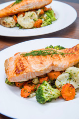 salmon fillet on a bed of broccoli, cauliflower and carrots