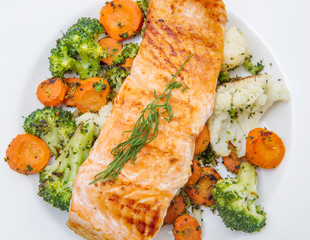 salmon fillet on a bed of broccoli, cauliflower and carrots