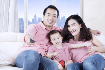 Fototapeta premium Asian family watching television in the apartment