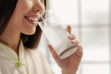 Smiling asian woman taking medication