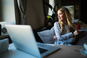 Beautiful woman using laptop at cafe