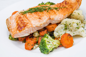 salmon fillet on a bed of broccoli, cauliflower and carrots