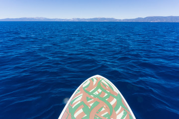 Point of view shot from a stand up paddleboard on the water of Lake Tahoe, California