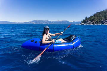 Young woman in hat and sunglasses enjoys watersports on a summer day at Lake Tahoe, California