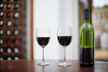Wine bottle and glasses on wooden table