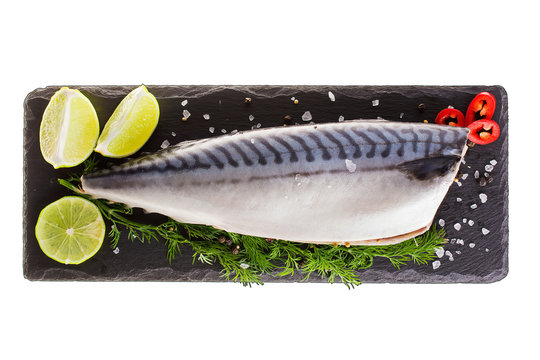 Raw mackerel with lemon and herbs on black slate cutboard