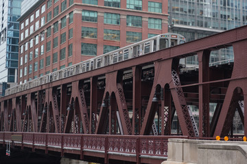 Naklejka premium Train driving on bridge in front of high-rise blocks