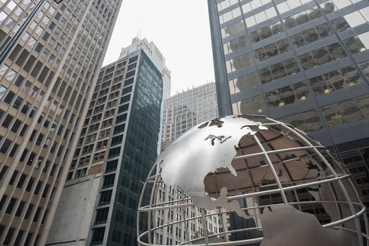 Huge globe situating near multi-storey buildings