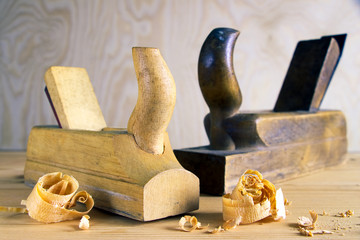 Old planes on wooden board, carpentry tools with wood shavings and sawdust