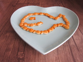 in the bowl of fish crackers on the wooden floor hearted 