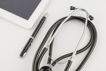 Tablet PC, stethoscope and pen on white background, medical concept