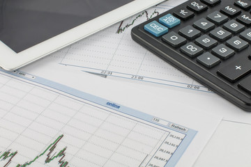Tablet computer, calculator and business graph on white background