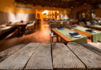 Empty wooden desk space and blurry background of restaurant vintage tone for product display montage