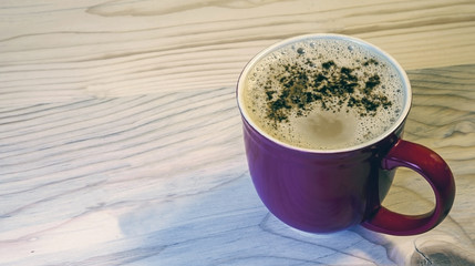 Coffee in red mug on wood background, close up retro / vintage shot.