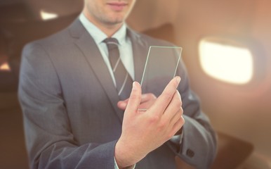Composite image of businessman using futuristic mobile phone