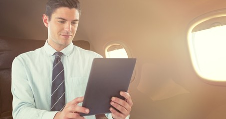 Composite image of businessman using digital tablet