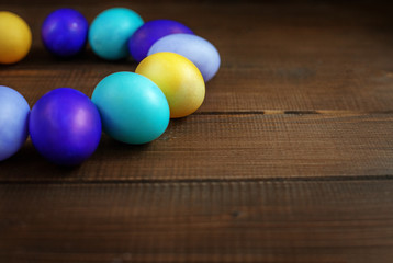 Wooden background with colored Easter eggs. Concept and happy Easter holiday.