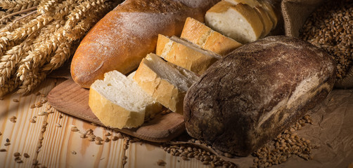 Assortment of baked bread on wooden table background