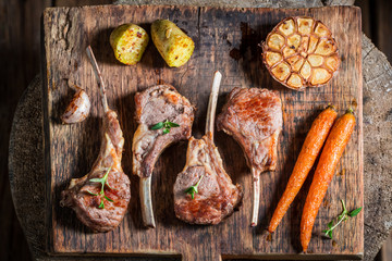 Hot roasted lamb ribs on the burnt black table
