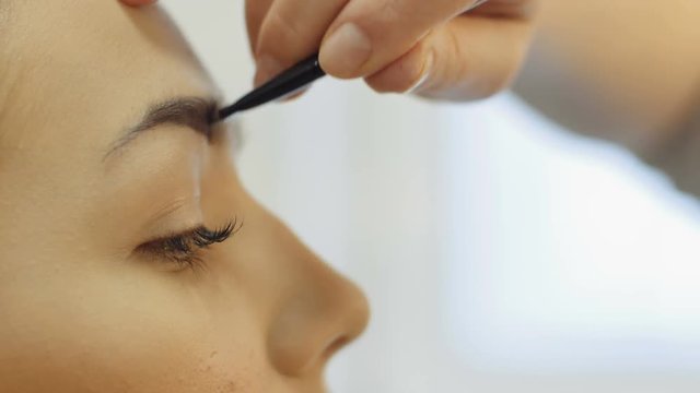 Professional makeup mascara application with brush - work in beauty fashion industry cosmetics