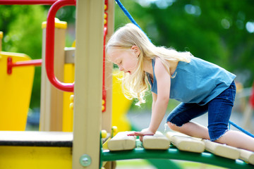 Cute little girl having fun on a playground outdoors