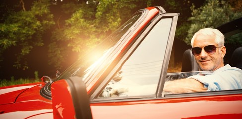 Handsome man enjoying his red convertible