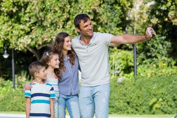 Fototapeta premium Happy family taking a selfie on mobile phone