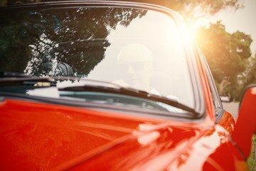 Man driving a red car 