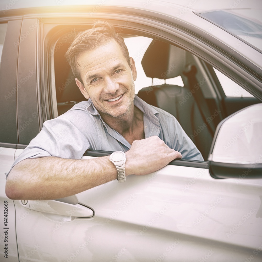 Poster man smiling at camera in a car