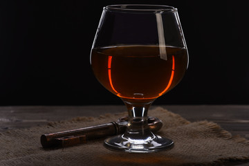 glass with cognac, whiskey and key on wooden table