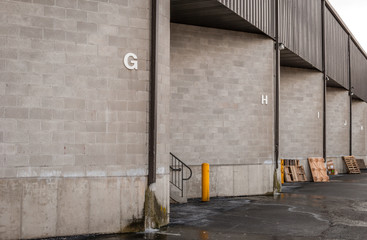 Warehouse dock garage doors. Loading dock bay garage. Storage facility loading areas. Industrial entry zones. Black and white design. Exterior architectural detail and design. Architecture detail.