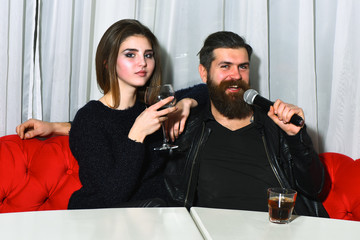 Romantic couple of pretty girl and bearded man at karaoke