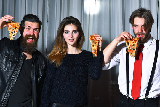 Happy friends eating tasty pizza slices with thumbs up gestures