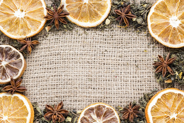 green tea with orange slices and star anise on canvas background top view. copy space.