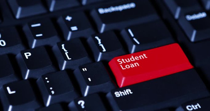 Human finger pushing a red button with text of Student Loan on the computer keyboard