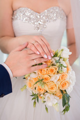 Obraz na płótnie Canvas Hands and rings on wedding bouquet